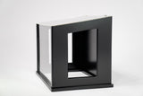 A black indoor dog potty with clear windows and black walls.